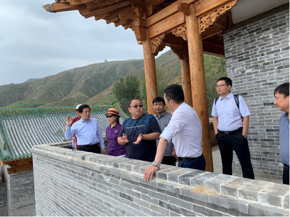 图为大同市经发投董事长张亮(前排右二)向专家组介绍李二口长城文化