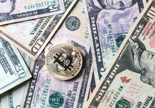 bitcoin-coin-on-bills-of-cash-money_925x